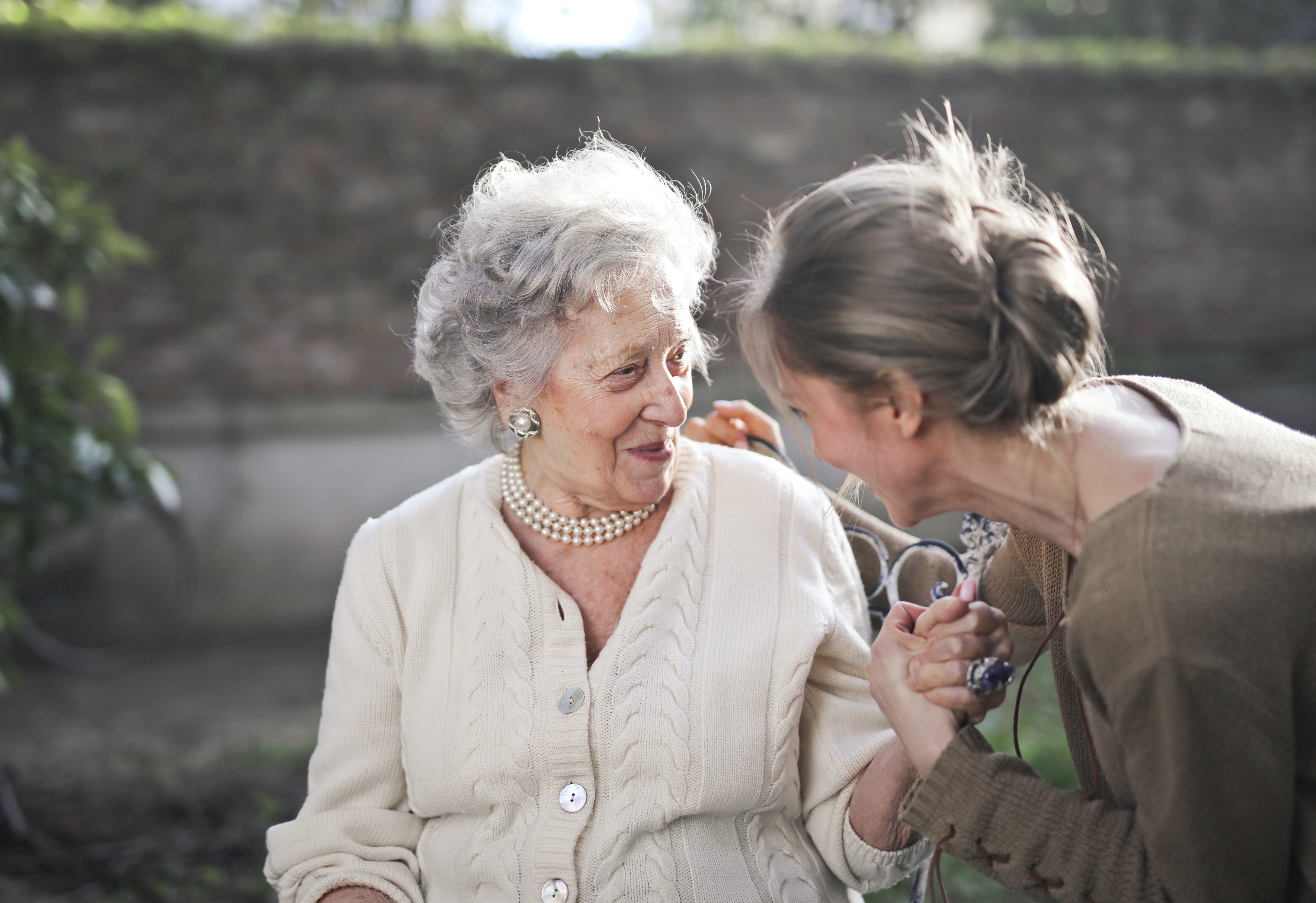 Older Woman Speaking with a Younger Woman Kneeling Beside Her