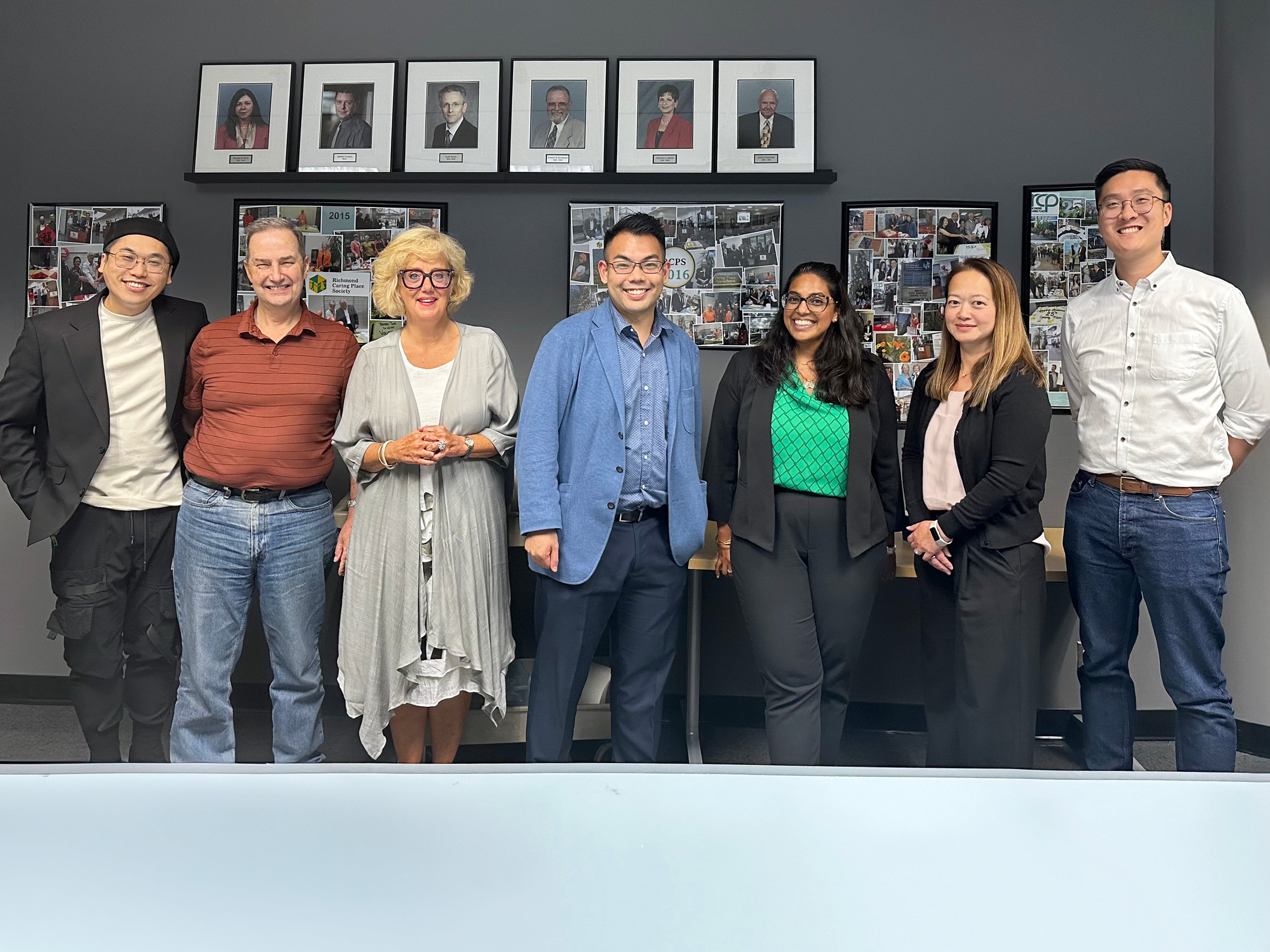 A group of people posing for a photo in a board room