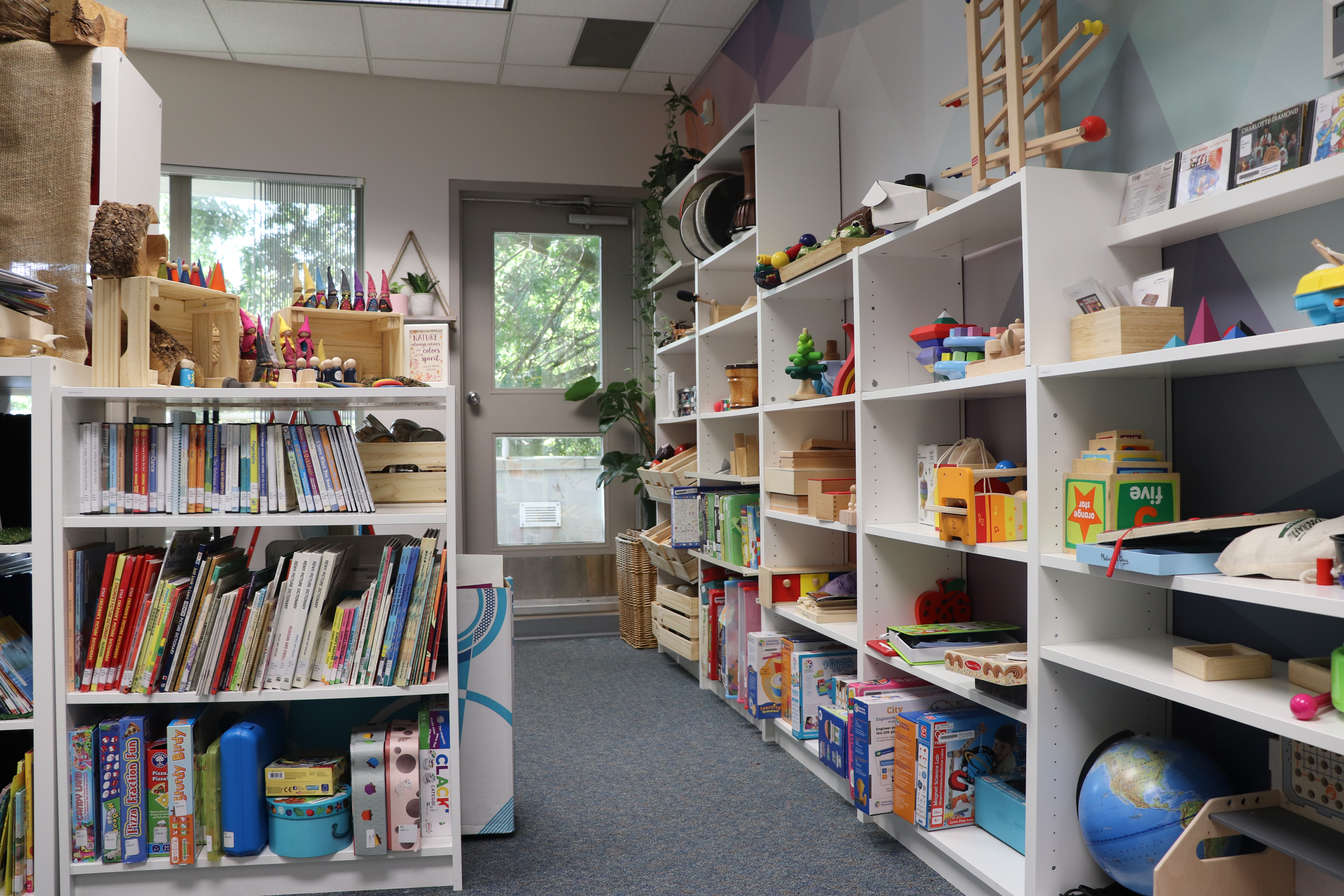 A children's library, its shelves filled with books, toys, and learning materials