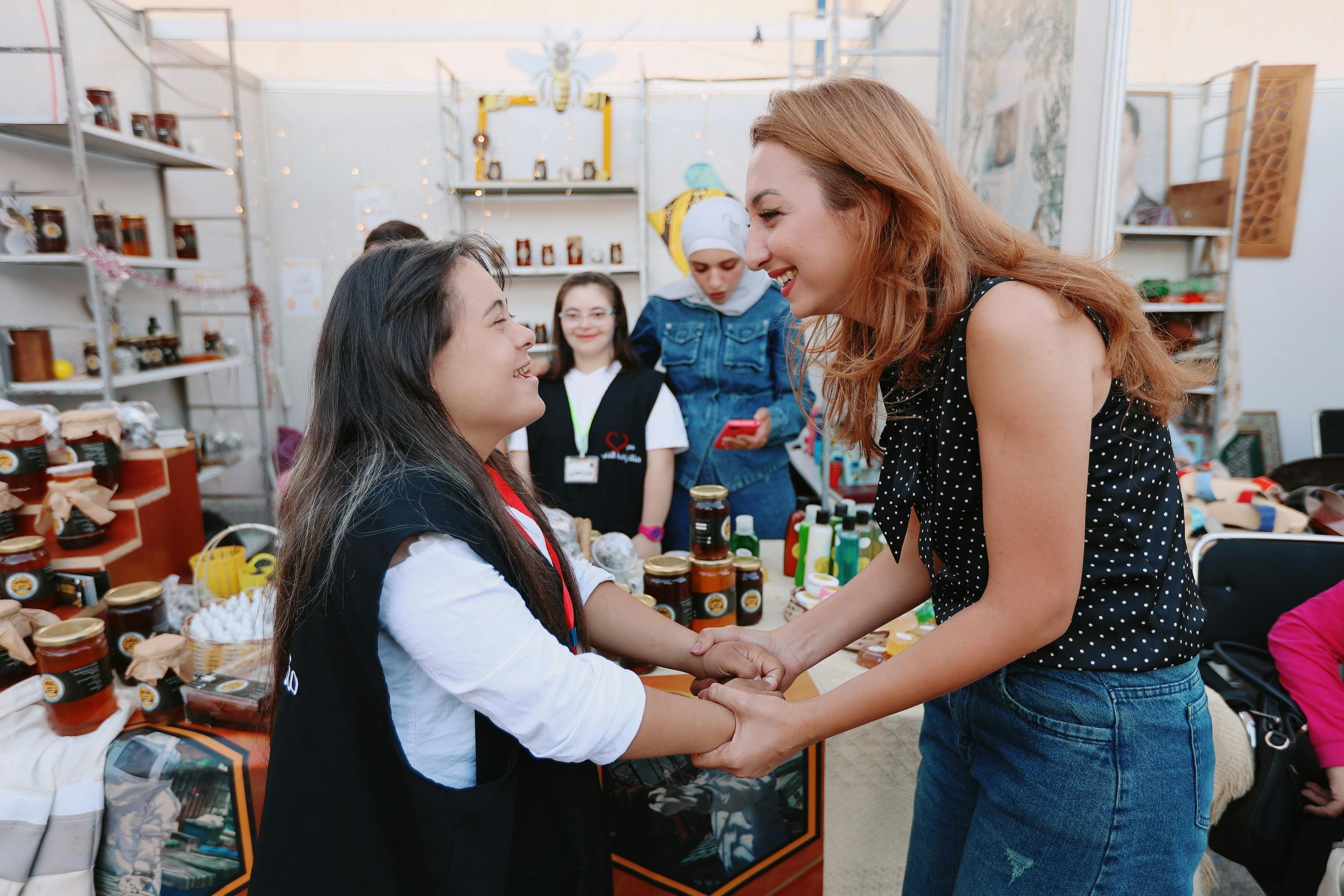 Two women smiling at each other, while one holds the other's hands