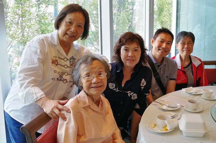 A group of seniors and volunteers sitting around a table, enjoying dim sum